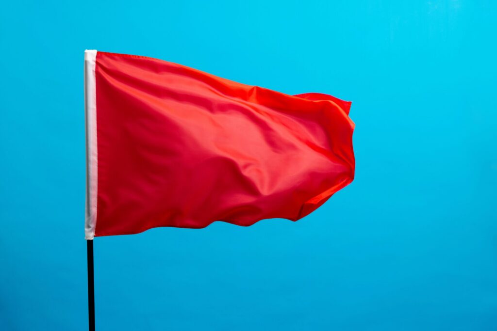 Red,Flag,Waving,On,Blue,Background.